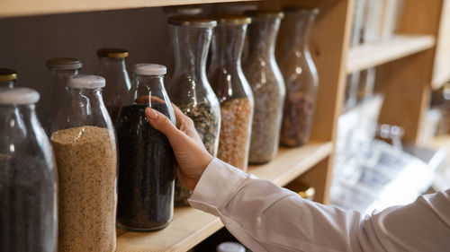 Close-up of hand holding glass bottles