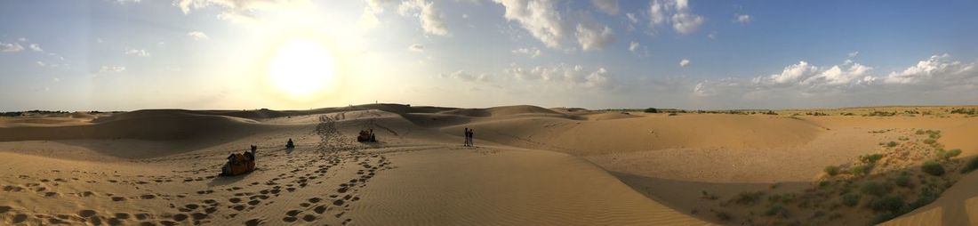 Panoramic view of desert against cloudy sky