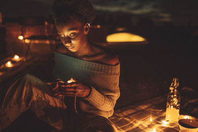 Midsection of man using mobile phone at night