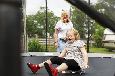 Smiling girls playing on trampoline