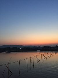 Scenic view of lake against clear sky during sunset