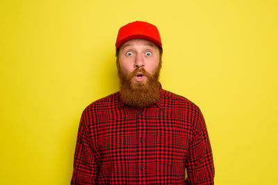 Portrait of man wearing hat against yellow background