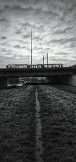 Bridge over river against cloudy sky