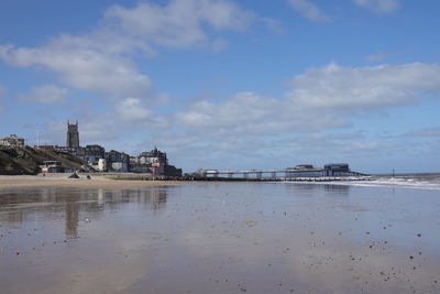 Scenic view of sea by buildings against sky