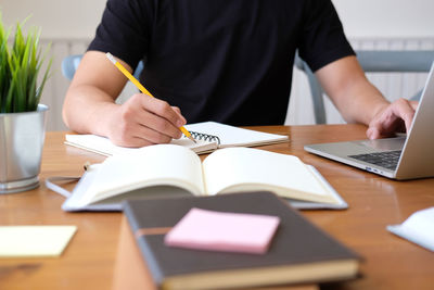 Midsection of student studying on table