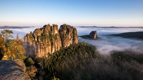 High angle view of rock formations by clouds against sky