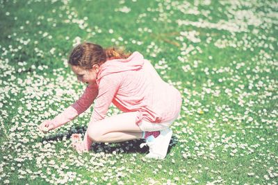 Side view of a girl sitting on grass