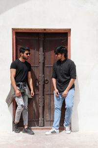 Full length of a young man standing against wall