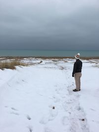 Full length of man standing on snow covered beach