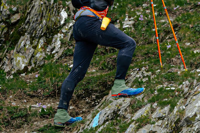 Low section of man climbing on rock