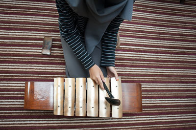 Directly above shot of woman playing gamelan