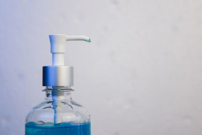 Close-up of glass bottle against blue water