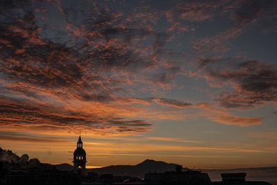 Silhouette buildings against sky during sunset