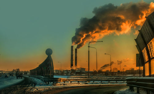 Panoramic view of factory against sky during sunset