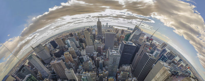 Aerial view of city against cloudy sky