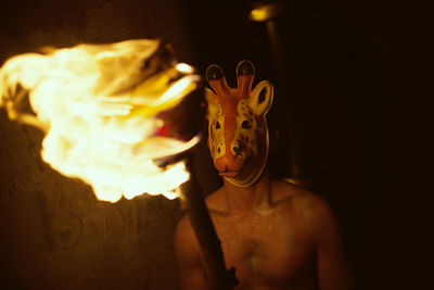 Full length of shirtless man against black background