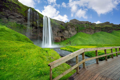 Scenic view of waterfall against sky