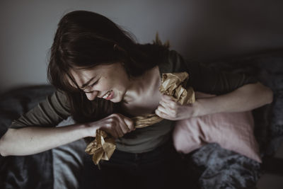 High angle view of angry woman tearing paper at home