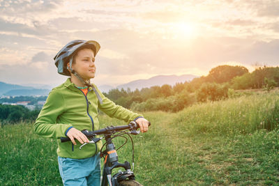 Portrait of boy riding bicycle on field