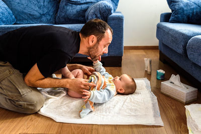 Father playing with baby at home