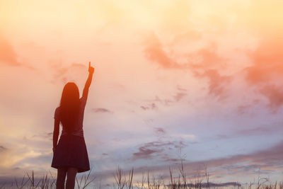 Silhouette woman standing against sky during sunset