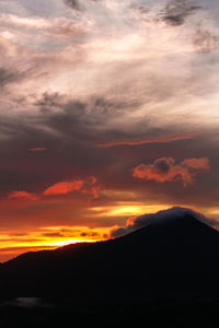 Scenic view of silhouette mountains against orange sky