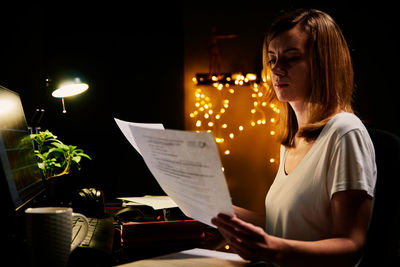 Tired woman works late at home workplace