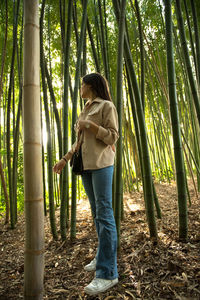 Rear view of woman standing in forest