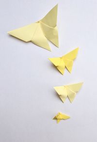 High angle view of yellow paper origami butterflies on white background