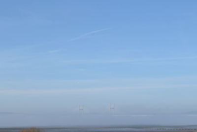 Severn bridge over seascape against blue sky