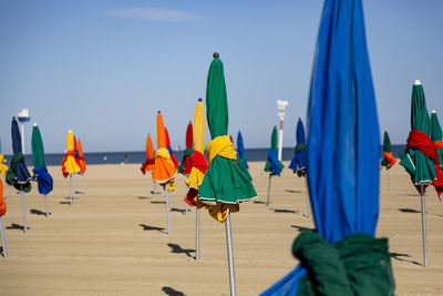 Multi colored umbrellas on beach against sky