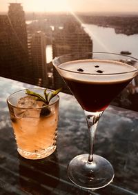 High angle view of drinks on table against city during sunset