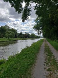 Road by trees against sky