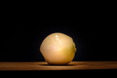 Close-up of oranges on table against black background