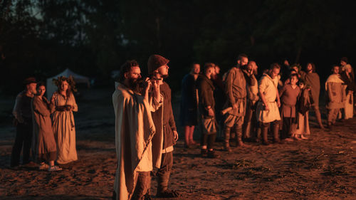 Group of people standing on land at night