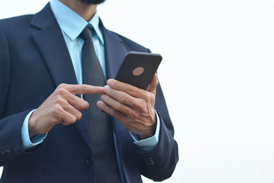 Midsection of man using mobile phone