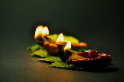 Close-up of burning candles on table