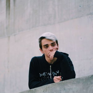 Thoughtful boy by retaining wall