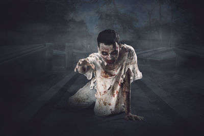 Digital composite image of man holding cross at night