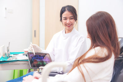 Portrait of smiling female doctor examining patient at clinic