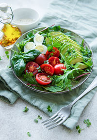 Fresh summer salad with arugula, red cherry tomatoes, basil, eggs and avocado. vegan food. 