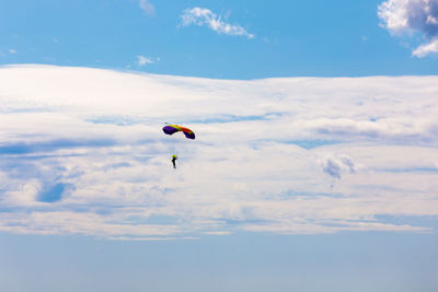 Low angle view of person paragliding against sky