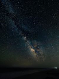 Scenic view of sea against star field at night