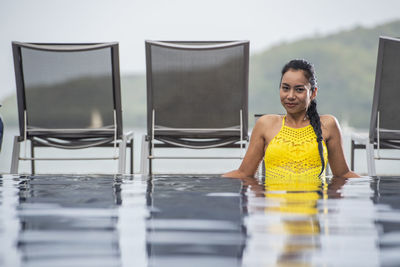 Beautiful woman enjoying a relaxing time in the pool of luxury resort
