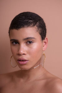 Close-up portrait of beautiful young woman against wall