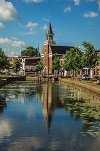 Canal with bascule bridge, church and townhouses in weesp. a pleasant small village in netherlands.