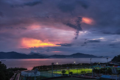 Scenic view of sea against dramatic sky during sunset