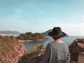 Rear view of man looking at sea against sky