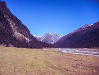 Scenic view of mountains against clear blue sky