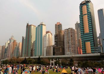 Crowd in city against sky